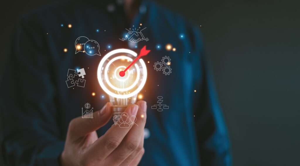 Hand holding illuminated lightbulb with digital marketing strategy icons, symbolizing innovation, customer engagement, and lead generation in SEO and advertising.