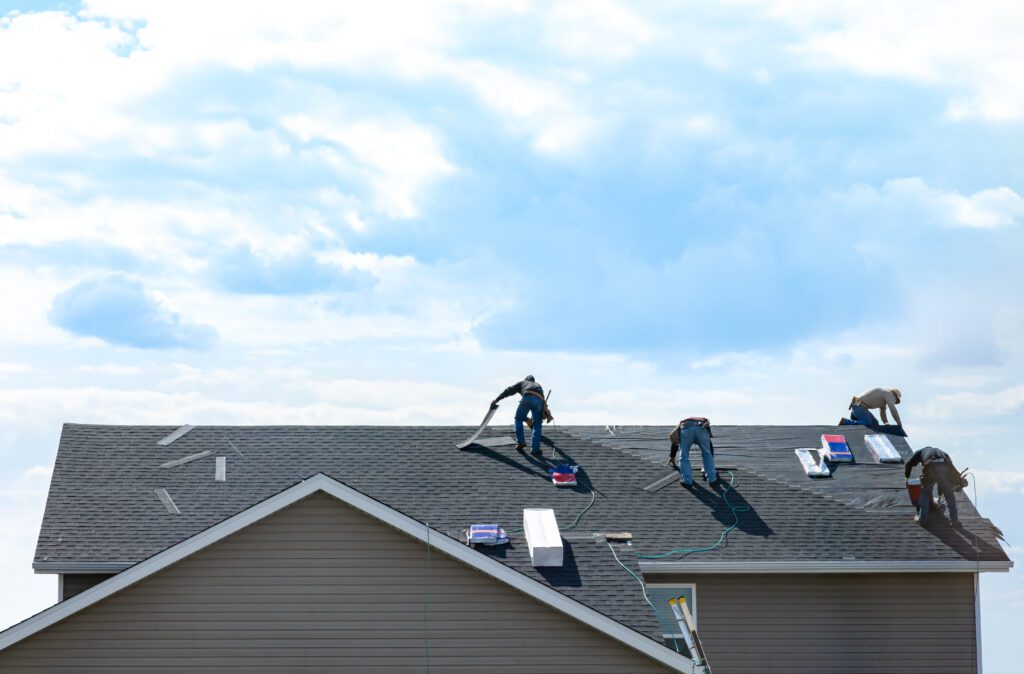 Roofers replacing shingles on a residential roof, highlighting lead generation for roofing companies using Google Local Service Ads and local SEO.