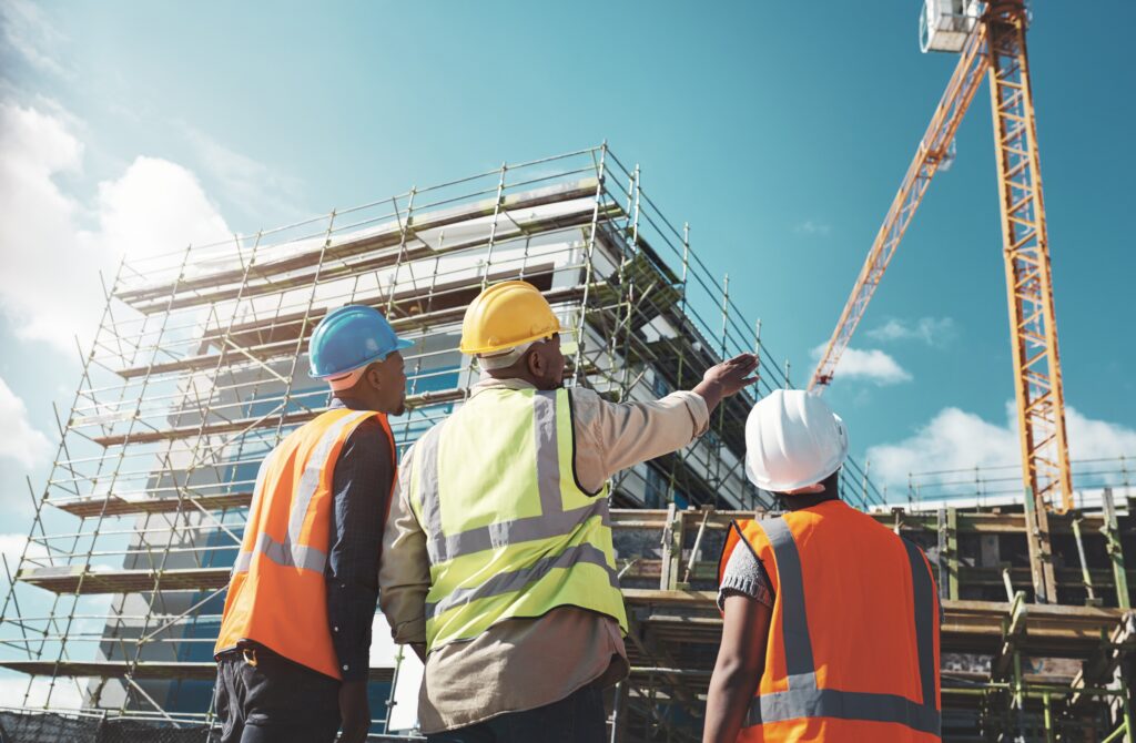 Construction contractors planning building site with scaffolding and crane, ideal for digital marketing and YouTube ads targeting home renovation, roofing, and general contracting services.