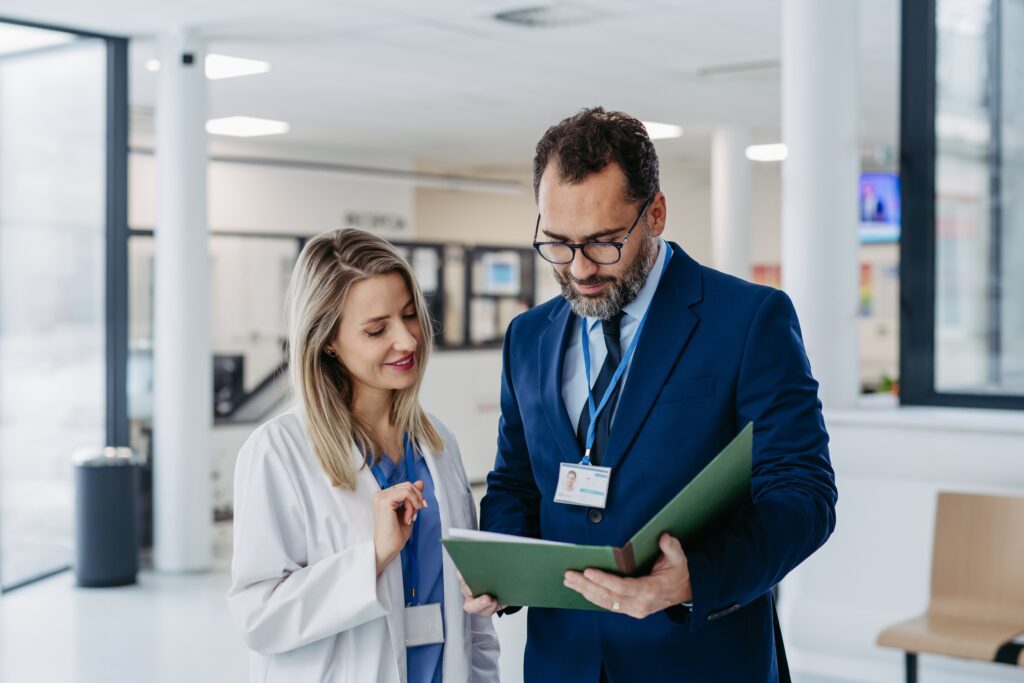 Doctor and healthcare executive evaluating patient consent and compliance policies—representing healthcare website design for risk management, transparency, and regulatory compliance.