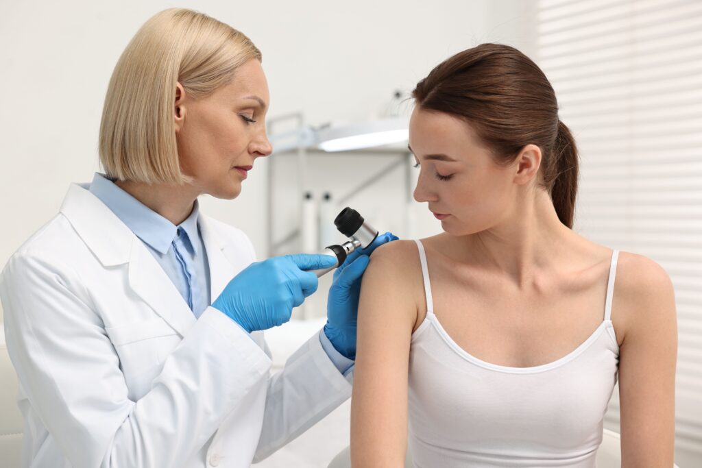 Dermatologist using dermatoscope to examine patient’s skin during consultation, representing targeted advertising and personalized healthcare services in dermatology Google Ads campaigns.