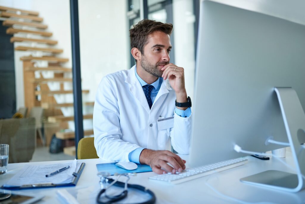 Healthcare provider analyzing protected health information on secure medical software—emphasizing HIPAA compliance, encryption, data governance, and medical web development for information security.