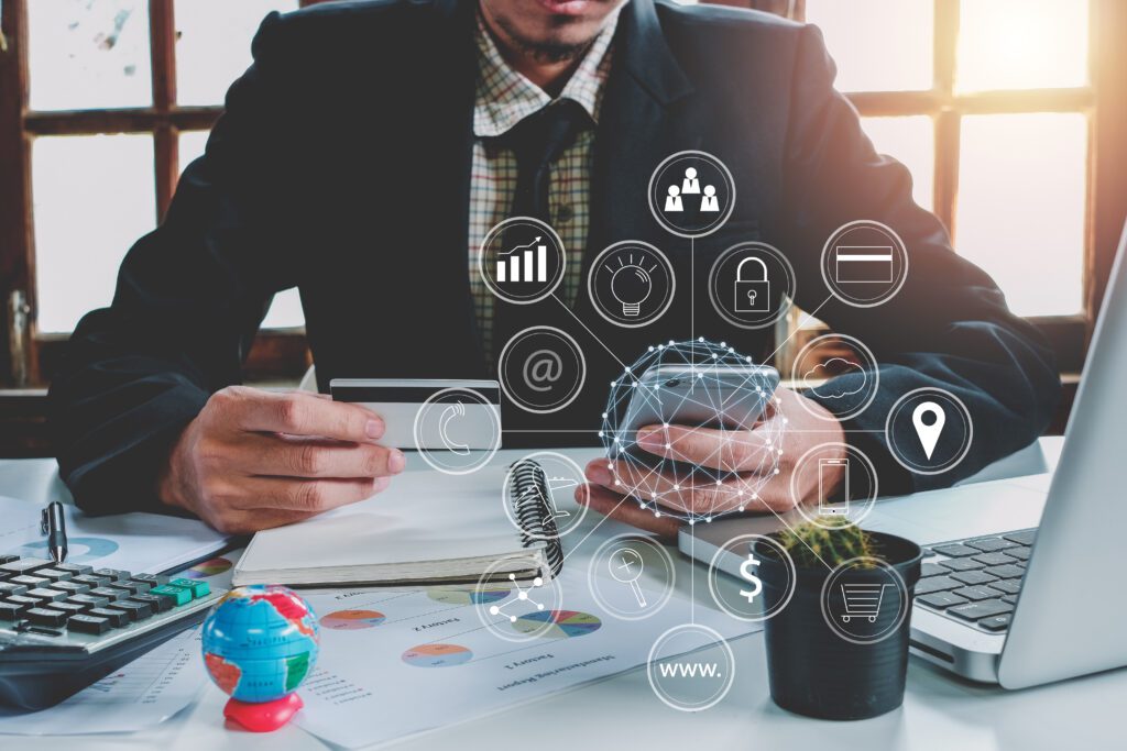 "Business professional using credit card and smartphone to manage online transactions with secure ecommerce applications. Overlay includes icons for customer data management, ecommerce marketing tools, customer relationship management, cloud infrastructure, personalization, and secure payment technology.