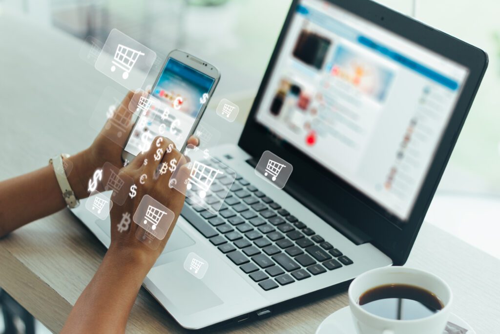 Online shopper using smartphone and laptop with ecommerce and currency icons, illustrating mobile commerce, digital sales strategies, and conversion-focused Amazon PPC advertising in 2025.