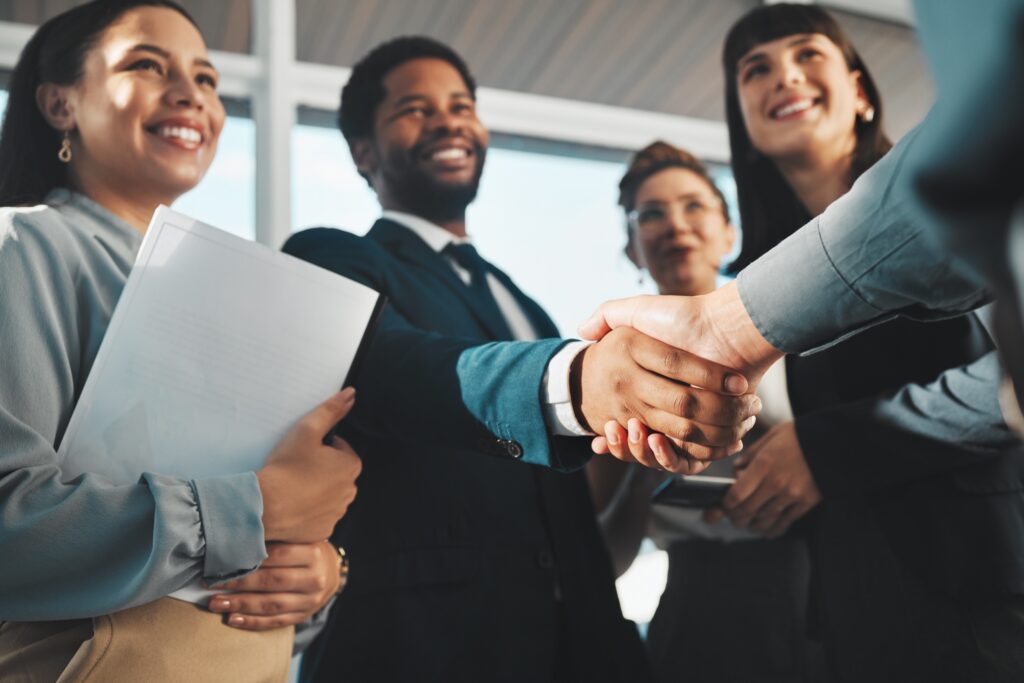 Business professionals shaking hands in a successful B2B ecommerce meeting, symbolizing customer acquisition, brand loyalty, and partnership in omnichannel marketing strategies.