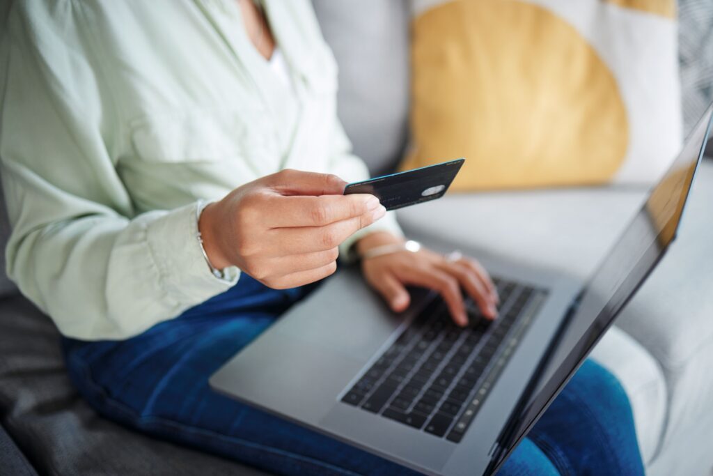Customer making a subscription purchase on a laptop with a credit card, highlighting ecommerce payment behavior, UX optimization, and involuntary churn prevention strategies for subscription services.
