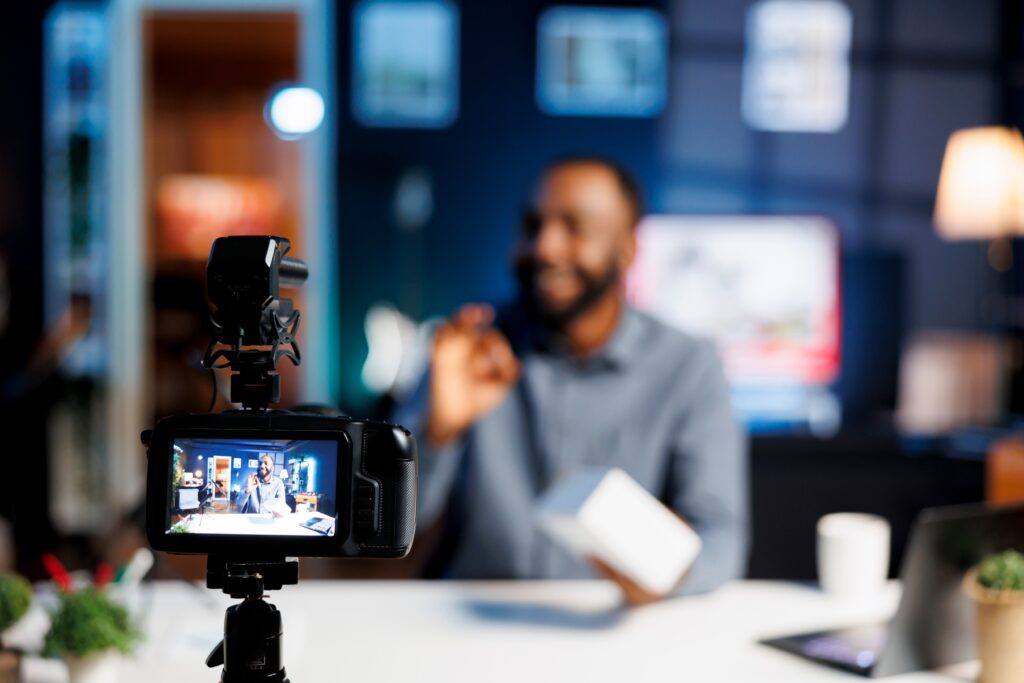 Influencer recording product review video for ecommerce campaign using professional camera setup, promoting user-generated content, brand visibility, and digital marketing strategy.