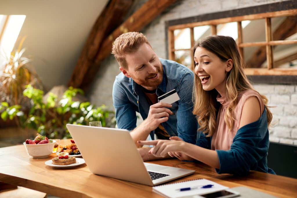 Excited customers completing an online purchase on a laptop, showcasing a smooth ecommerce checkout process and optimized product page design to boost conversion rates.