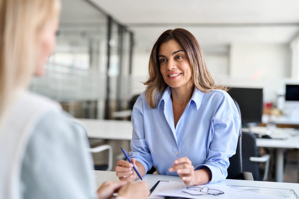 Female professional in a modern office discussing lead generation strategies with a colleague, representing CRM integration, marketing automation, and digital marketing for professional service firms.