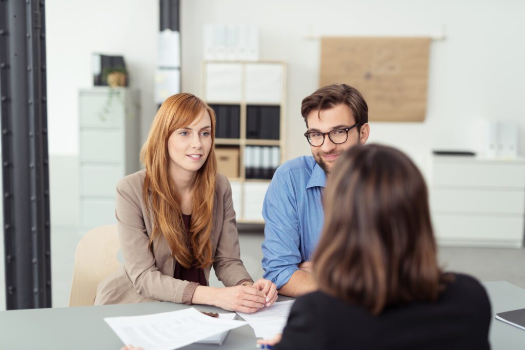 Young couple meeting with a consultant in a professional office setting, symbolizing personalized lead nurturing, automated sales funnels, and customer relationship management in business lead generation.