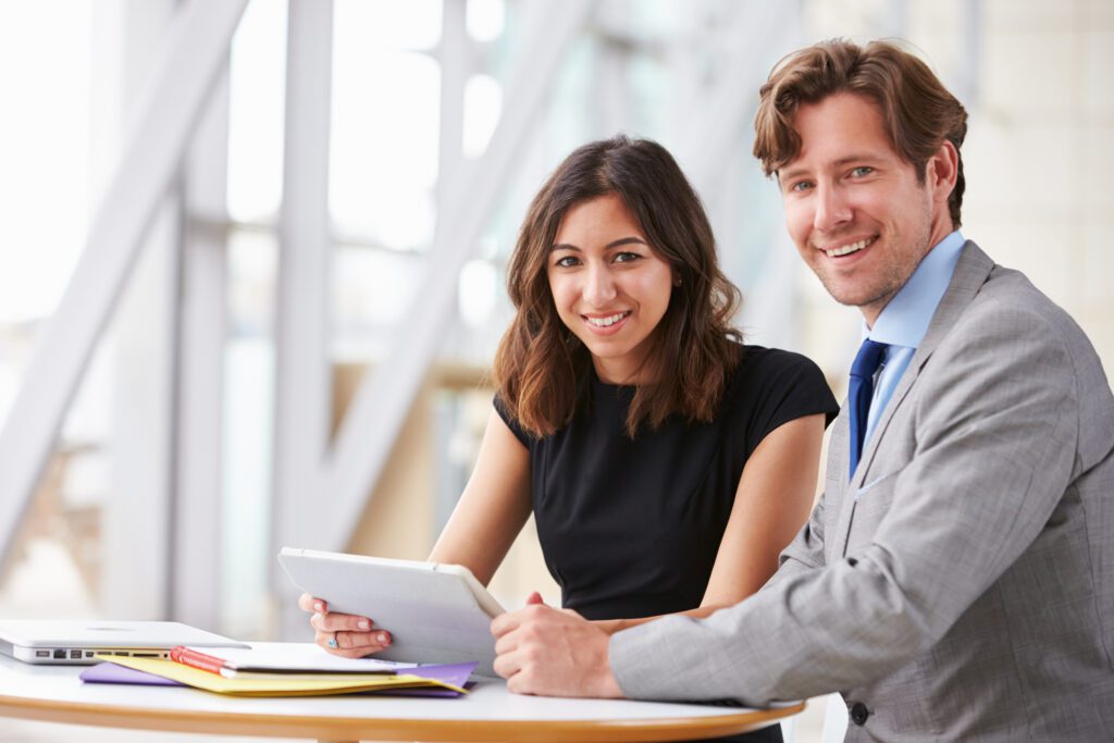 Consultants reviewing a digital marketing strategy on a tablet, emphasizing content marketing, mobile marketing, and lead generation for small business marketing.