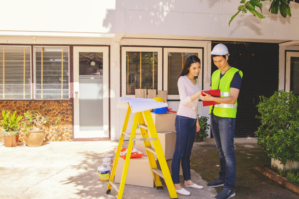 Home remodeling contractor discussing project plans with a homeowner outdoors, showcasing personalized customer experience and referral marketing in home improvement services.