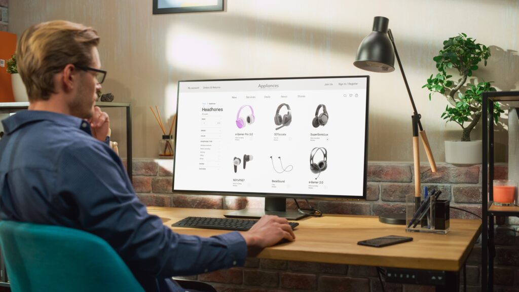 Ecommerce customer browsing online store product listings on desktop computer, showcasing digital marketing strategy, product data optimization, and online shopping behavior.